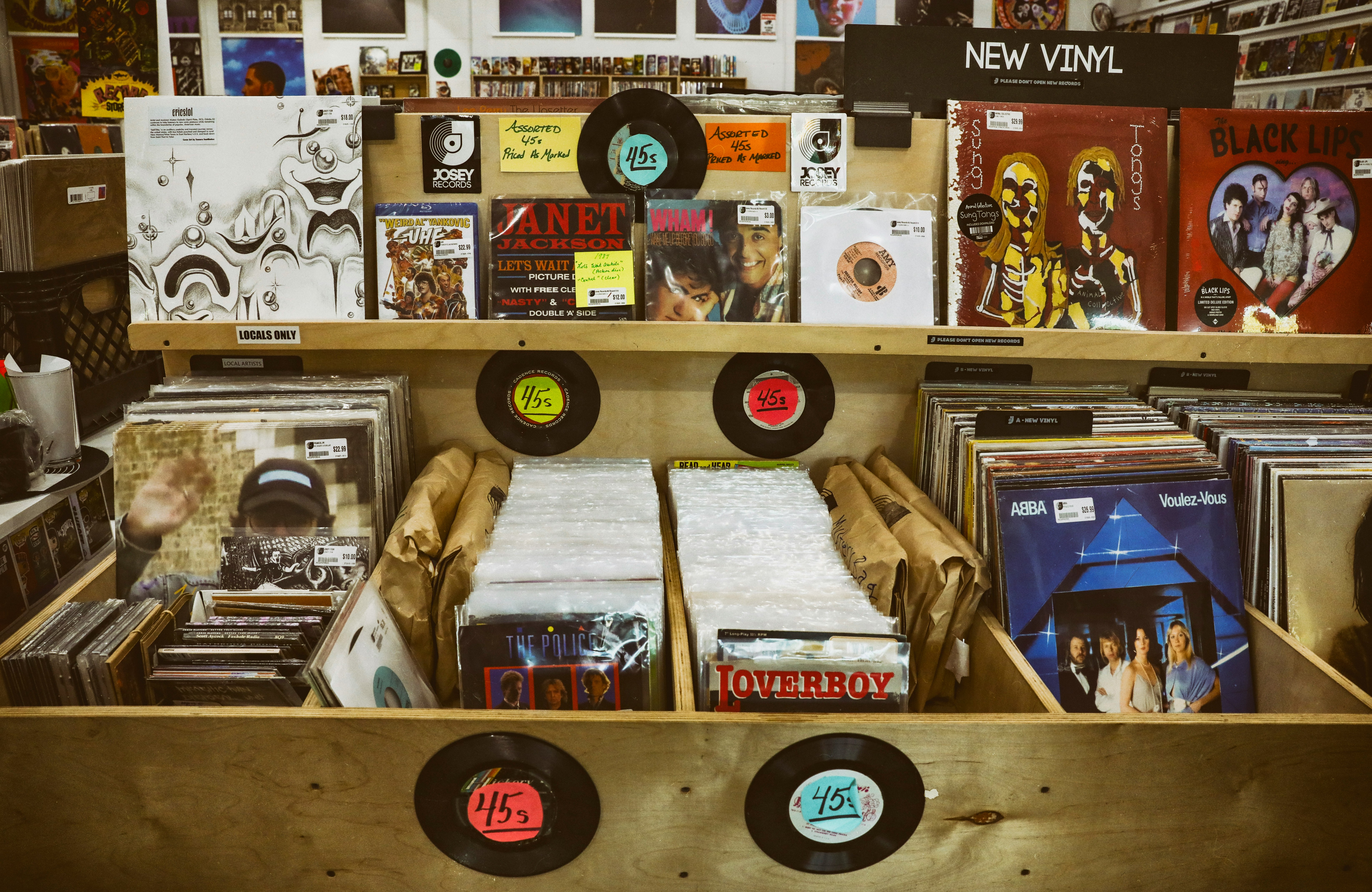 assorted vinyl figures on brown wooden shelf